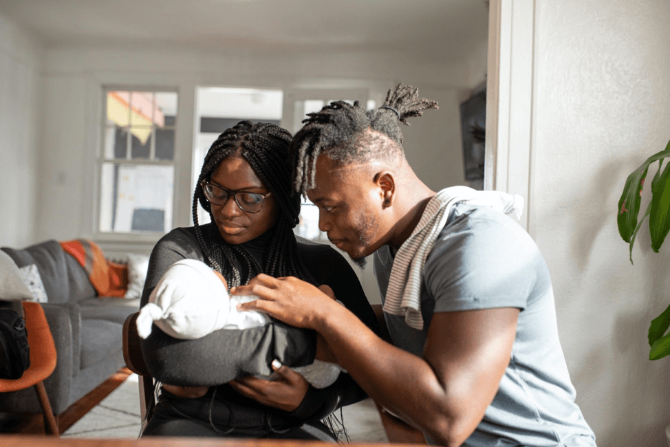 parents swaddling a newborn