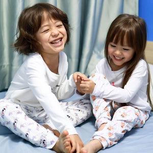 siblings laughing in the wee bean organic bamboo sleepwear in bunny rabbit candy