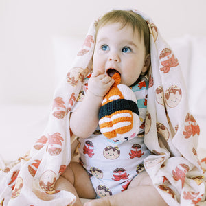 girl holding the wee bean sustainable and handmade fair trade rattle dolls by pebblechild in ebi shrimp sushi