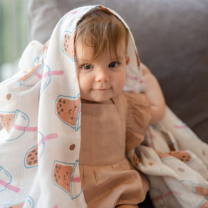 cute baby playing peekaboo in the wee bean super soft organic cotton and bamboo swaddle in boba bubble tea