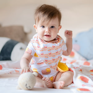 smiling baby wearing the wee bean organic cotton bib in hong kong milk tea