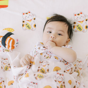 little boy on the wee bean milestone blanket in japan lucky cat